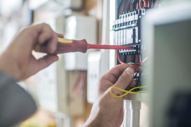 Elektriker som jobbar i ett elskåp